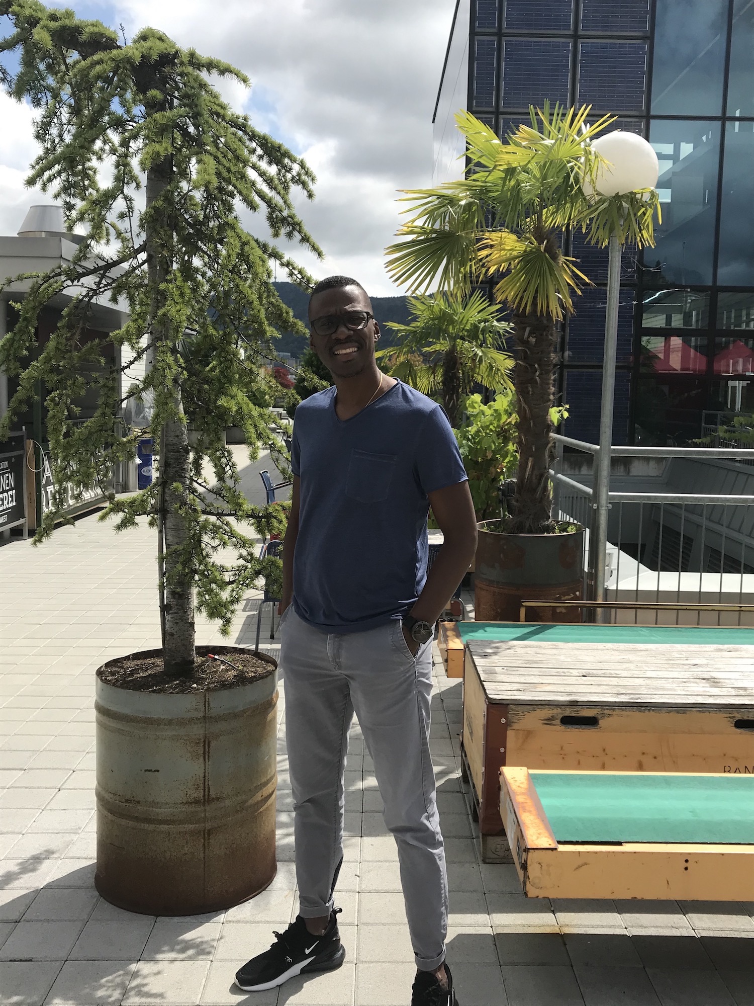 Mann steht auf der Dachterrasse bei Salsarica und blinzelt in die Kamera